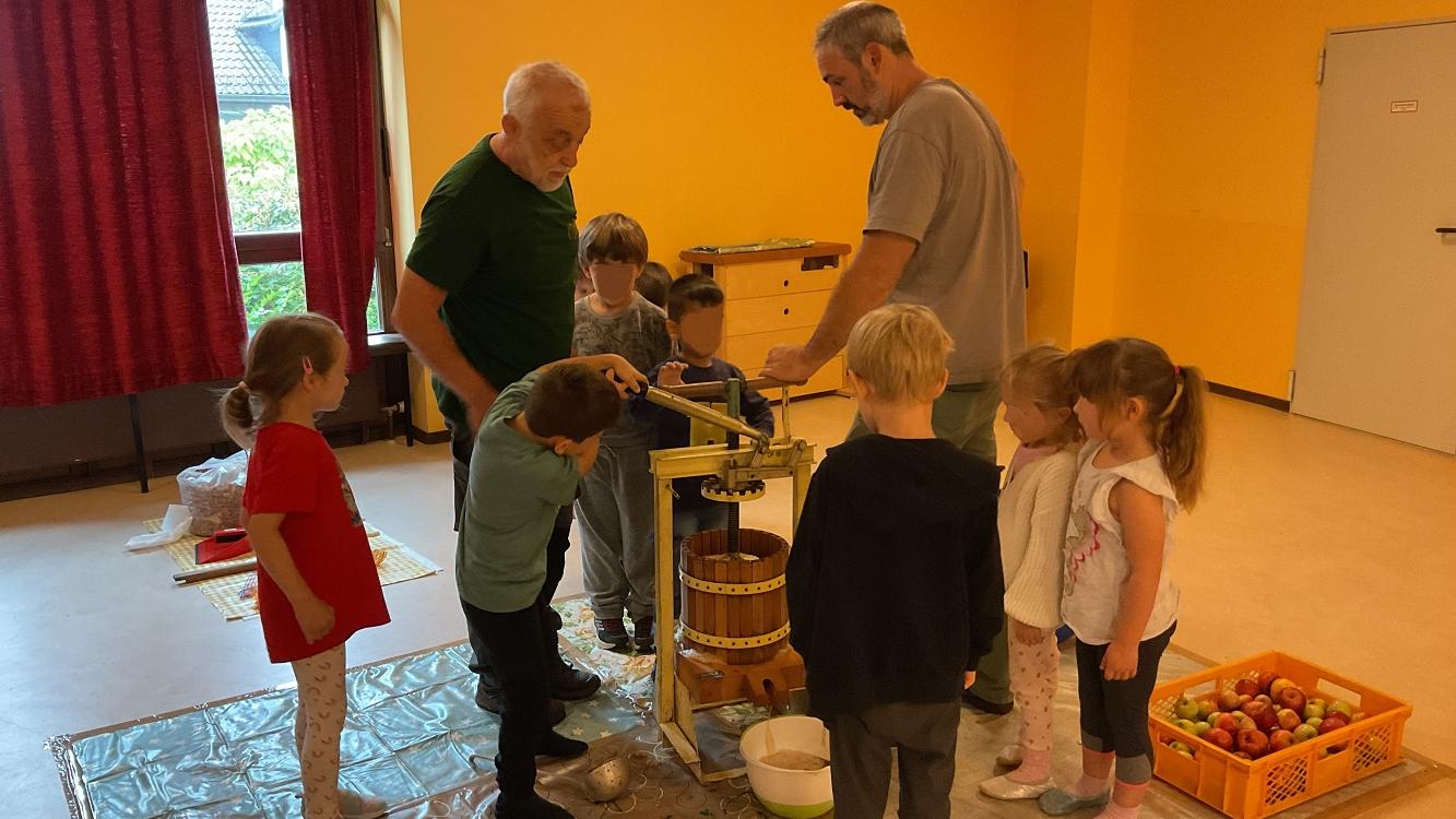 Gemeinsam stellen die Kinder frischen Apfelsaft her